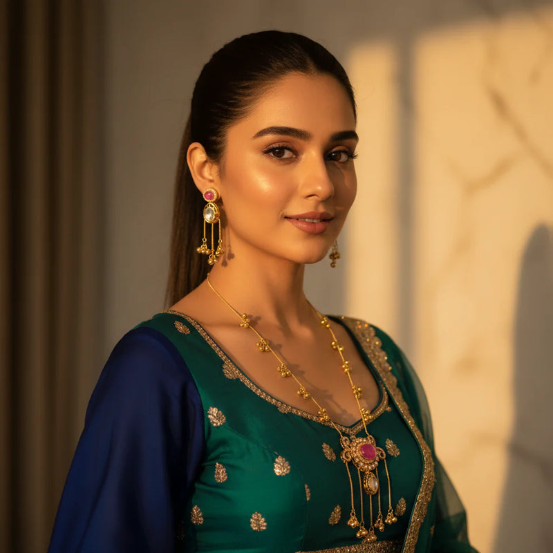 South Asian model wearing Kashmiri ruby polki long pendant necklace set with matching earrings in teal navy wedding outfit