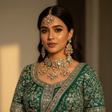 Model wearing blush pink kundan geometric choker set with earrings and tikka on green lehenga wedding