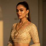 Model wearing gold plated meenakari long necklace set with floral chain and statement pendant and matching earrings on ivory lehenga