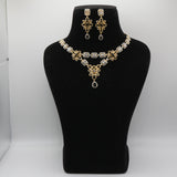 Gold and black necklace and earrings set on a black mannequin bust against a white background