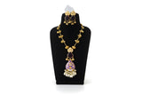 Close up of purple meenakari pendant with dark green stone earrings