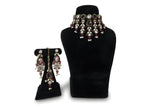 Pink polki kundan wedding choker necklace set with long earrings and maang tikka on black display stand