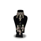 Blush pink kundan wedding choker necklace set with long earrings on black display stand