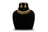 Antique gold kundan choker necklace set with jhumka earrings and ghungroo drops on black display stand