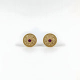 Close up of gold plated circular floral filigree stud earrings with ruby red centre stone and beaded border