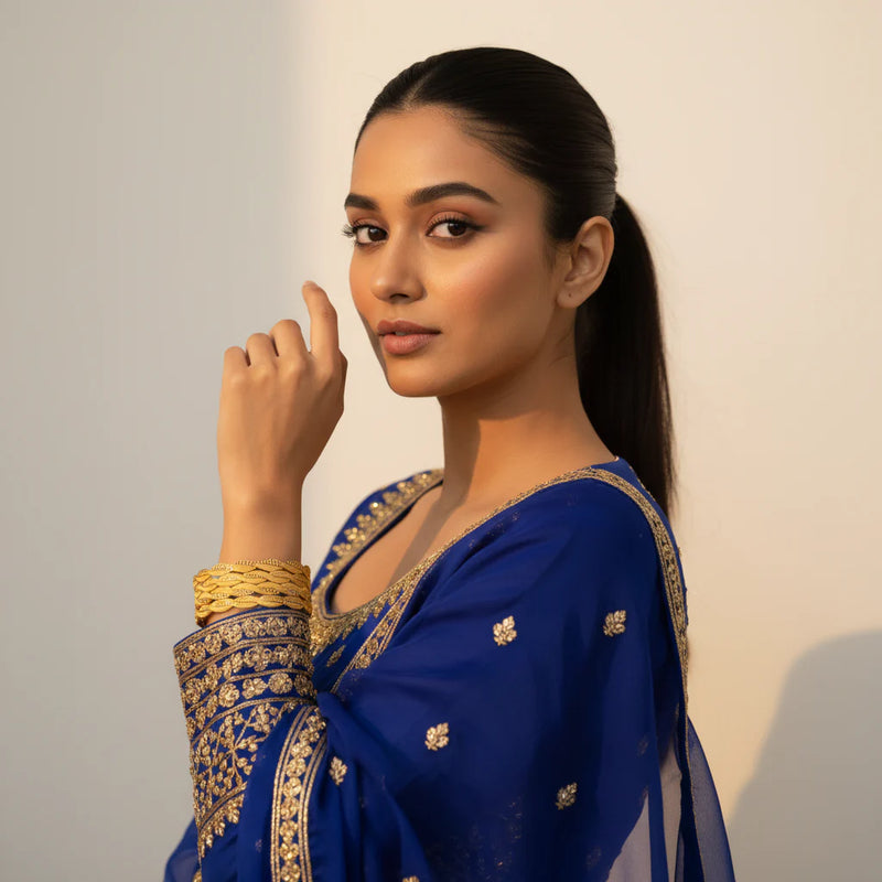 South Asian woman wearing gold plated lattice weave bangles set of 4 stacked on wrist royal blue outfit Jewellery by Aman