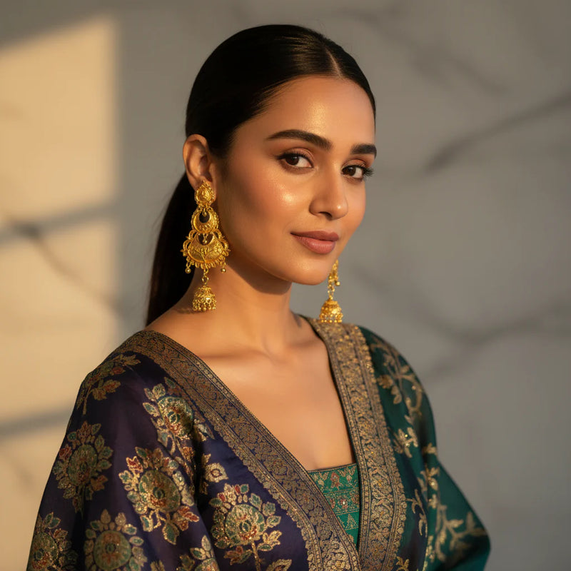 South Asian woman wearing gold plated chandbali jhumka earrings with crescent and fan drop on banarasi outfit