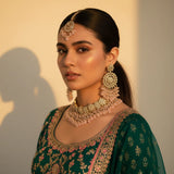 South Asian model wearing blush pink polki wedding set with choker necklace chandbali earrings tikka and passa in green embroidered outfit