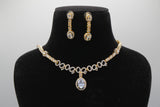 Gold necklace and earrings set on a black bust against a white background