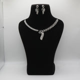Black necklace and earrings on a black mannequin bust against a white background
