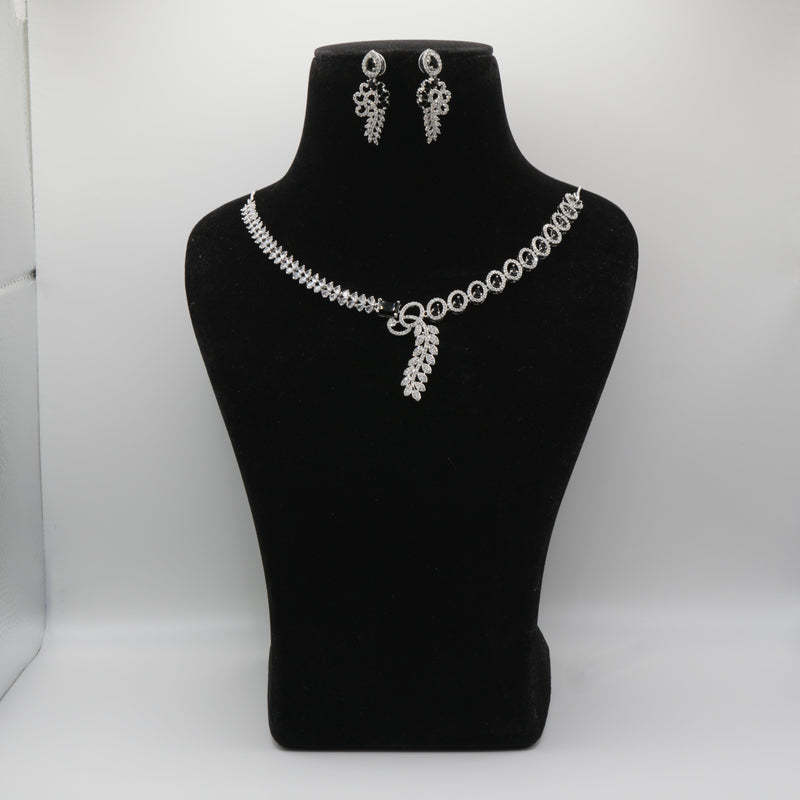 Black necklace and earrings on a black mannequin bust against a white background