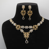 Close up of Gold and black necklace and earrings set on a black mannequin bust against a white background