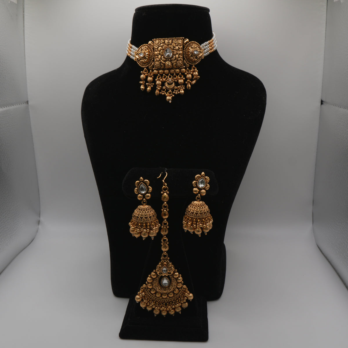 Ananya Kundan Centrepiece Choker Set — gold plated centrepiece pendant choker with clear kundan stones, pearl strand sides and gold bead drops, matching jhumka earrings and large teardrop maang tikka