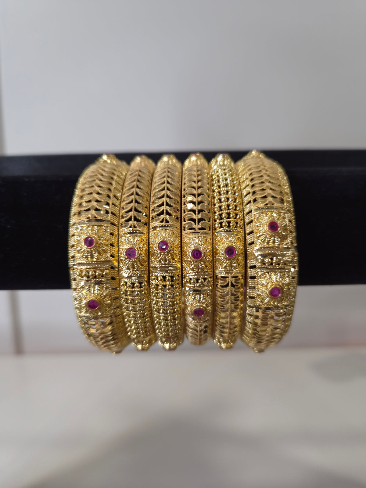 Banarasi Ruby Filigree Kada Set — set of 6 thick gold filigree kada bangles with intricate cut-work and ruby pink stone accents