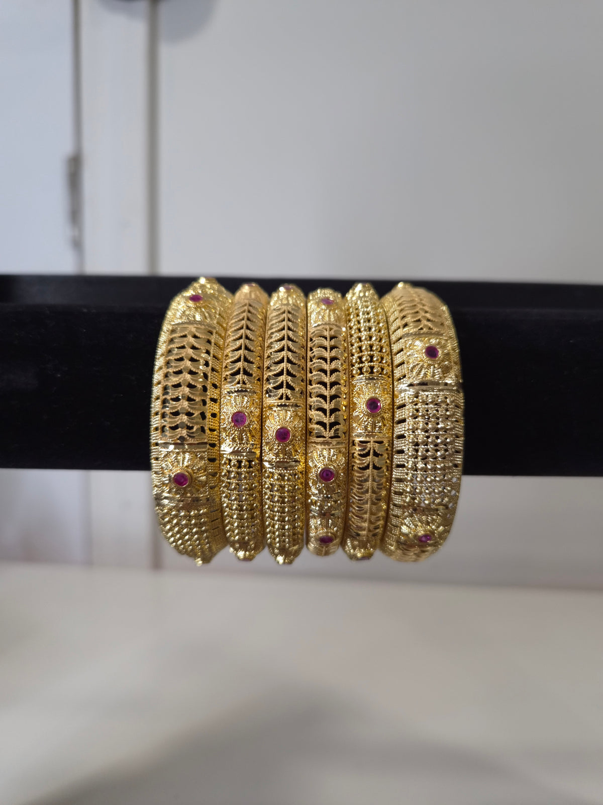 Banarasi Ruby Filigree Kada Set — set of 6 thick gold filigree kada bangles with intricate cut-work and ruby pink stone accents