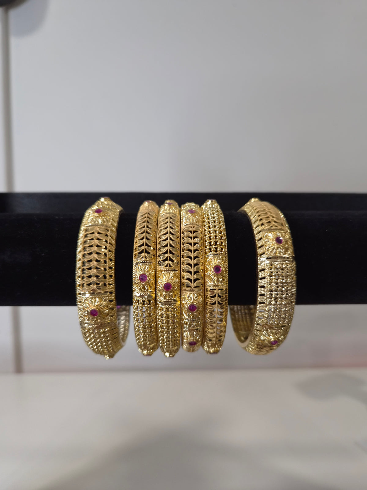 Banarasi Ruby Filigree Kada Set — set of 6 thick gold filigree kada bangles with intricate cut-work and ruby pink stone accents