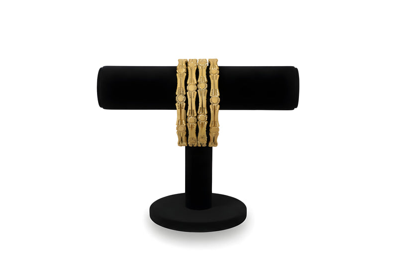 Gold plated filigree medallion bangles set of 4 displayed on black velvet stand front view