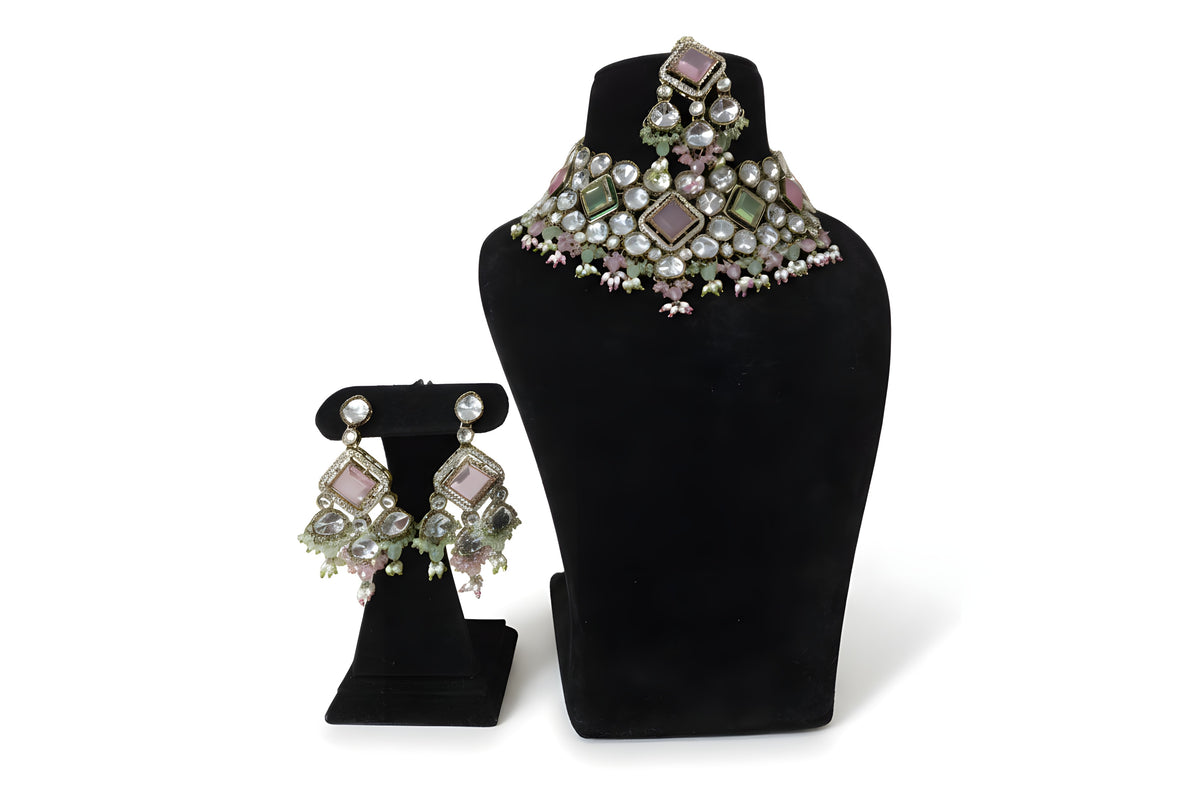Pink mint kundan polki choker necklace set with matching earrings on black velvet stand full view
