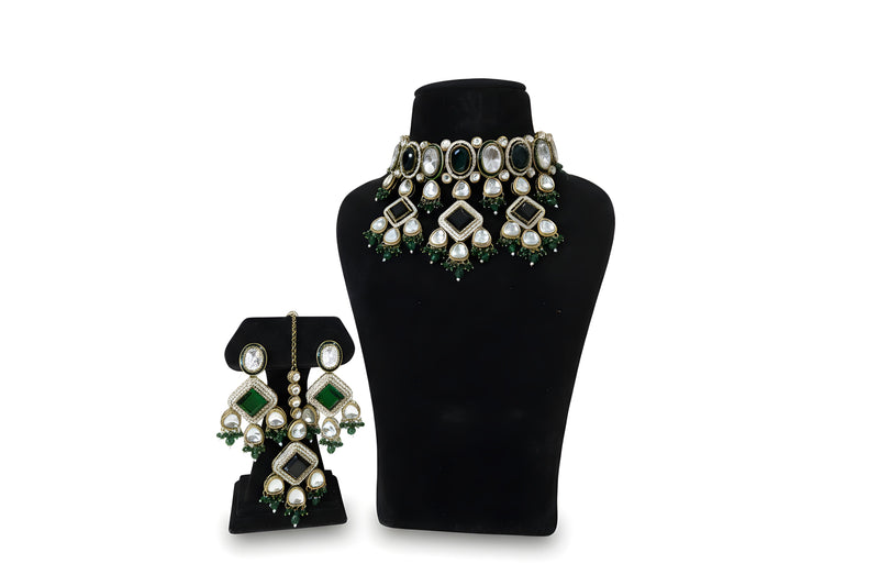 Close up emerald green kundan earrings and tikka with diamond CZ pave centre stone and crystal drops