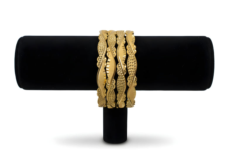 Gold plated wavy diamond cut engraved bangles set of 4 with serpentine wave pattern on black stand front view