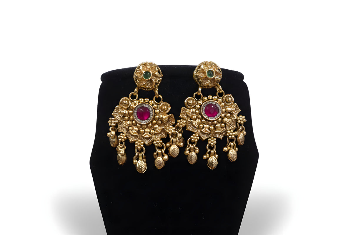 Close up of antique gold chandbali earrings with ruby centre stone and gold leaf drops - Jewellery by Aman