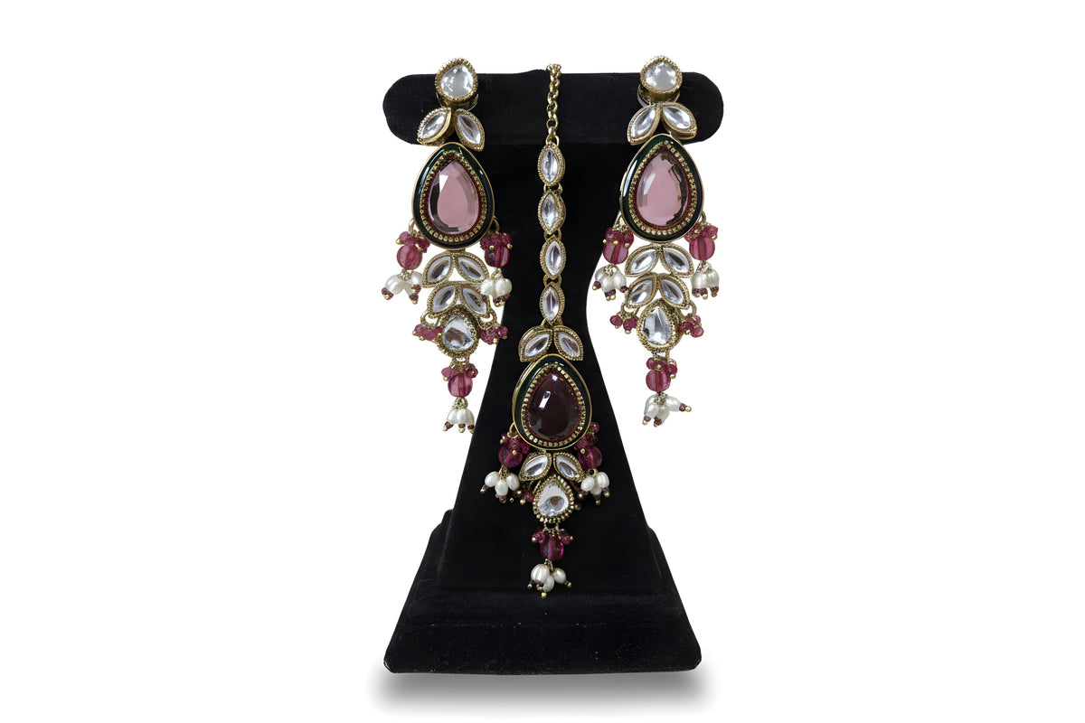 Close up of pink polki kundan drop earrings and tikka with green enamel teardrop and pearl drops - Jewellery by Aman