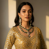 South Asian woman wearing pink white polki kundan wedding choker set with long earrings and tikka on gold lehenga