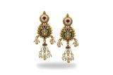 Close up of antique gold meenakari kundan earrings with green teardrop and pearl fringe - Jewellery by Aman