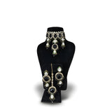 Jet black kundan wedding choker necklace set with long earrings on black display stand