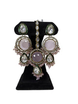 Close up of blush pink kundan long drop earrings and tikka with green enamel and pink crystal drops
