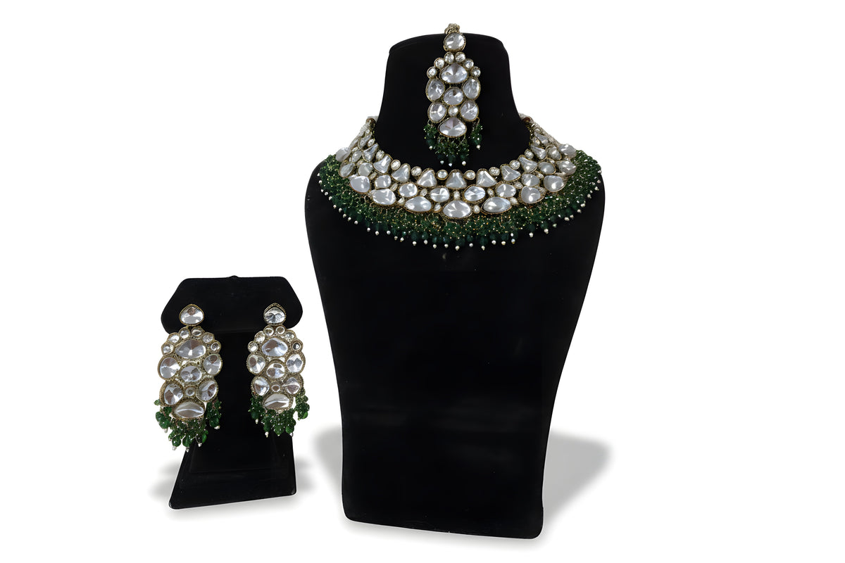 Polki kundan wedding choker necklace set with large earrings tikka and emerald green bead fringe on black display stand