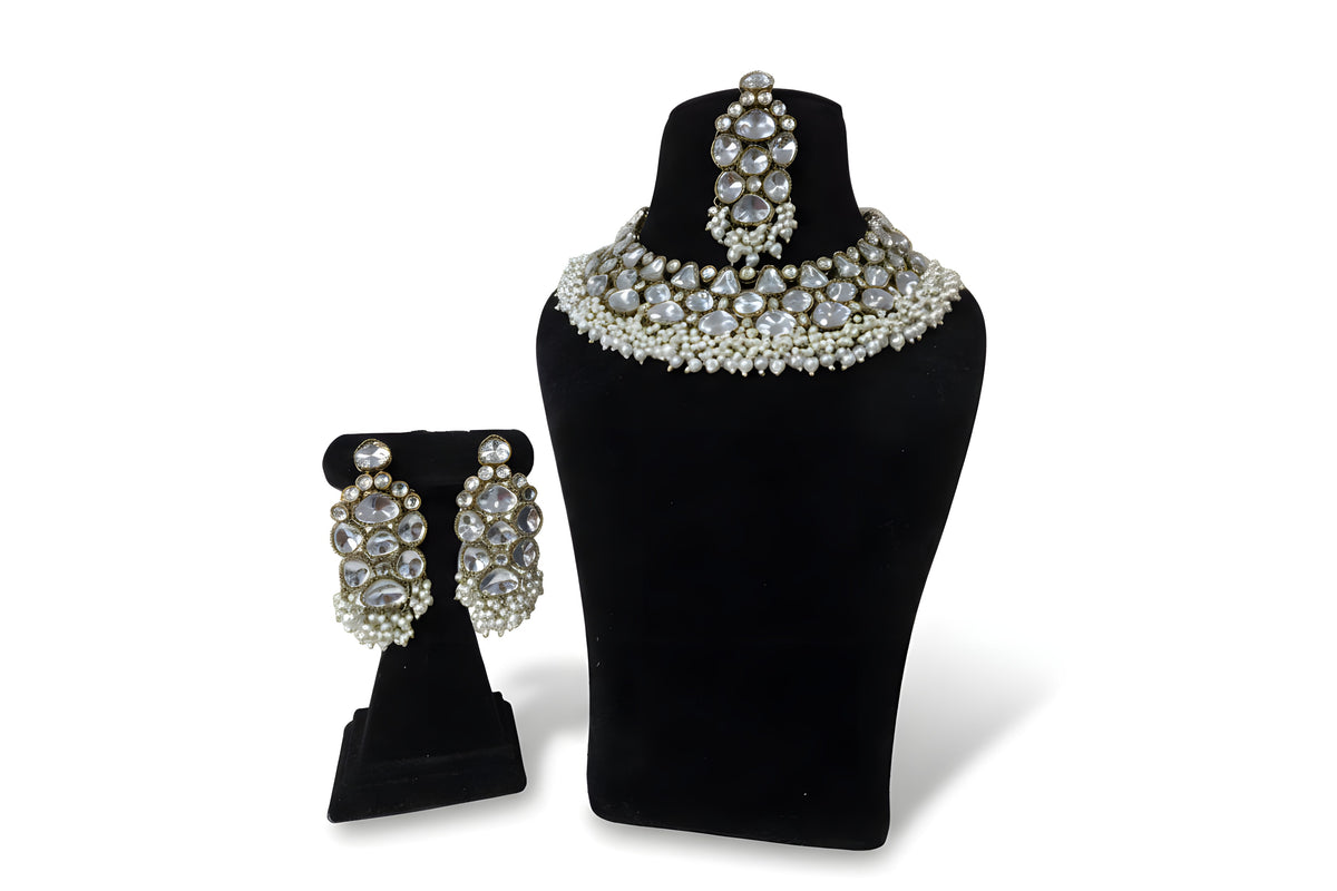 Polki kundan wedding choker necklace set with large earrings tikka and pearl bead fringe on black display stand