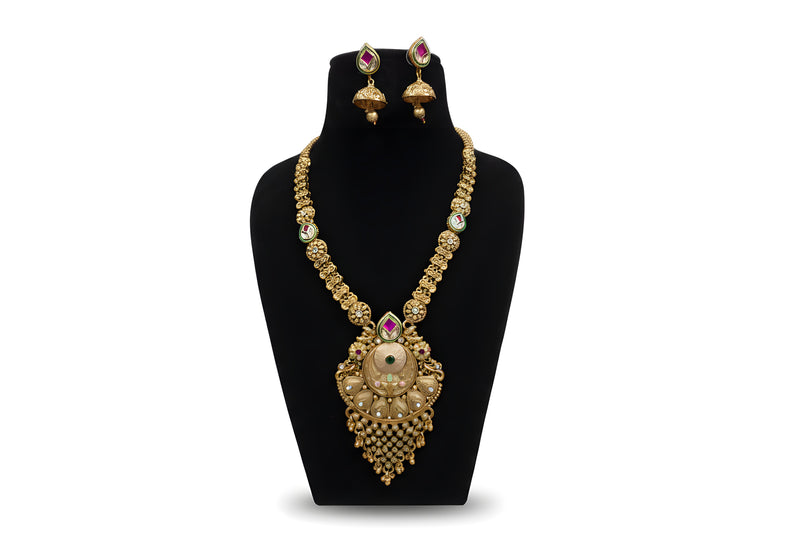 Antique gold long floral chain necklace set with large pendant ghungroo drops and jhumka earrings on black display