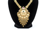Close up of antique gold ornate pendant necklace with emerald centre ruby teardrop and cascading ghungroo ball drops