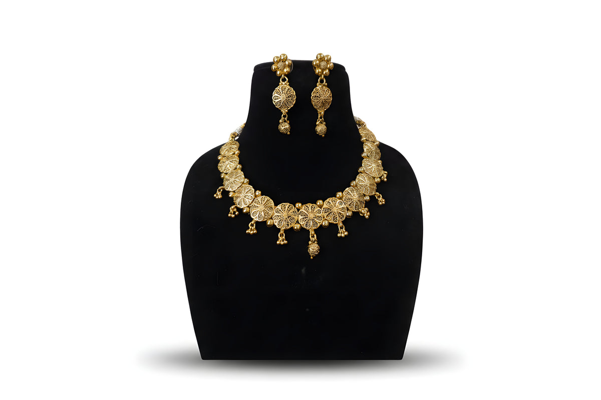 Gold plated filigree flower choker necklace set with drop earrings and gold ball drops on black display stand