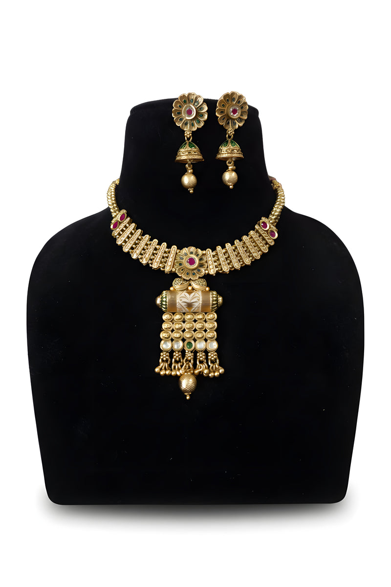 Antique gold meenakari pendant necklace set with jhumka earrings ruby accents and ghungroo drops on black display