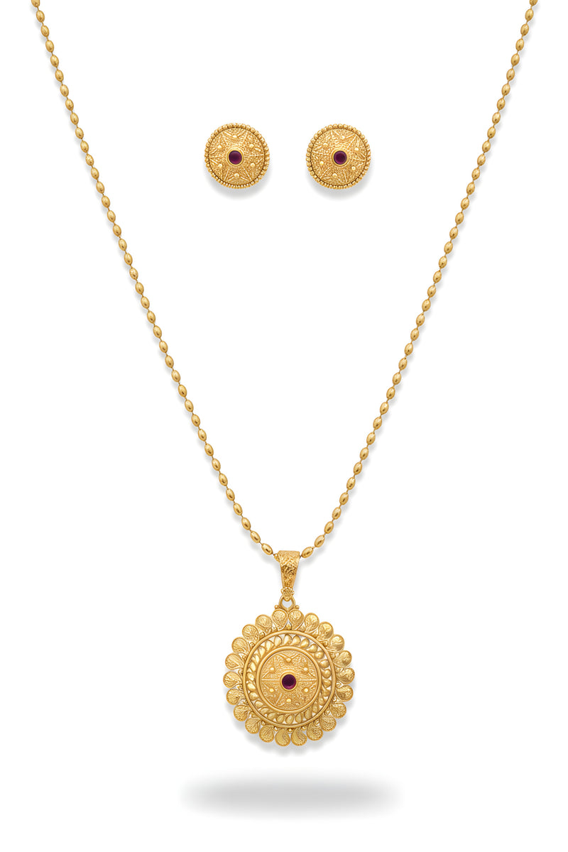 Gold plated floral filigree circular medallion pendant necklace and matching ruby centre stud earrings on black velvet bust